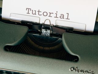 Eine alte Schreibmaschiene mit eingezogener Seite, auf der Tutorial steht.