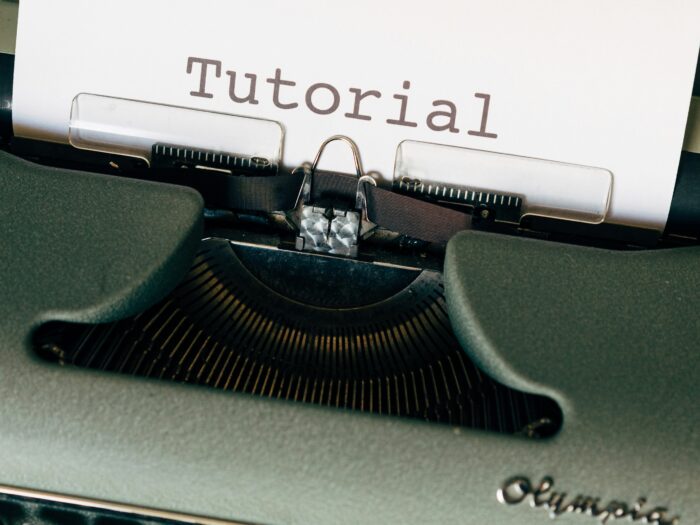 Eine alte Schreibmaschiene mit eingezogener Seite, auf der Tutorial steht.