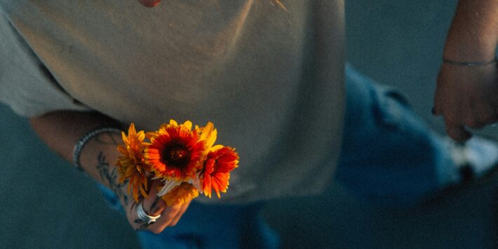 Ein junger Mensch mit Blume