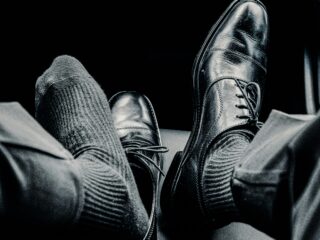 Schwarze Schuhe auf Autositz