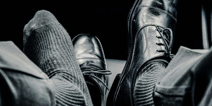 Schwarze Schuhe auf Autositz